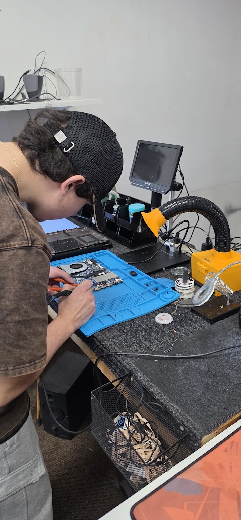 Adam working on a computer at the repair bench